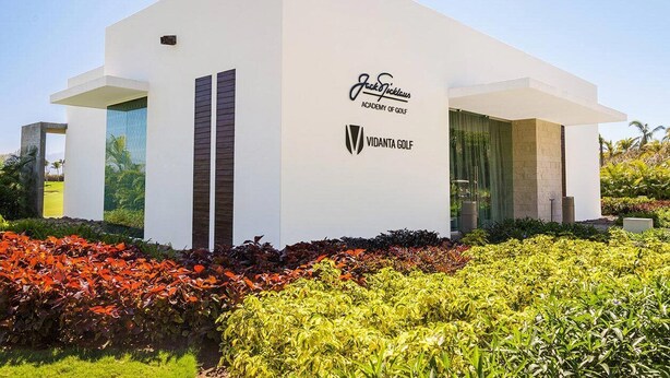 Ein modernes Gebäude mit weißer Fassade, mit dem Jack & Jillous Academy of Golf und dem Vidanta Golf Logo.