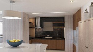 Eine moderne Küche mit einer Glastischplatte, einer Zitronenschale und einer schwarz gesprenkelten Spritzschutzwand.
