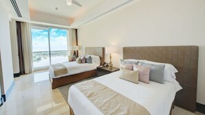 Ein Hotelzimmer mit zwei Betten, einem Deckenventilator, einem großen Fenster mit Vorhängen und Blick ins Freie.