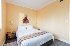 Une chambre d’hôtel avec un lit, des tables de chevet et un élément décoratif mural.