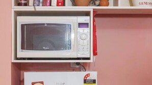 A kitchen with a microwave, a refrigerator, and a toaster. - Coral Atelier Bright Artistic Hideaway in the CBD (Melbourne)