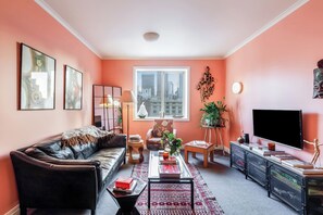 Un salon comprenant un canapé, une table basse, un téléviseur et des objets de décoration.