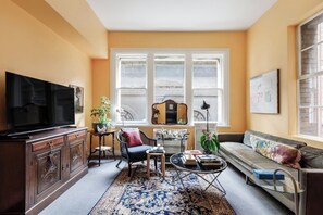 Ein Wohnzimmer mit Fernseher, Sofa, Couchtisch und Dekorationselementen.