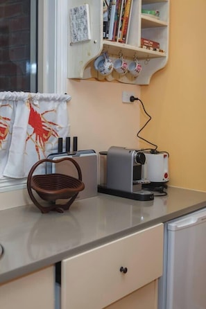 Eine Küche mit Toaster, Wasserkocher, Korb und einem Fenster mit Vorhang.