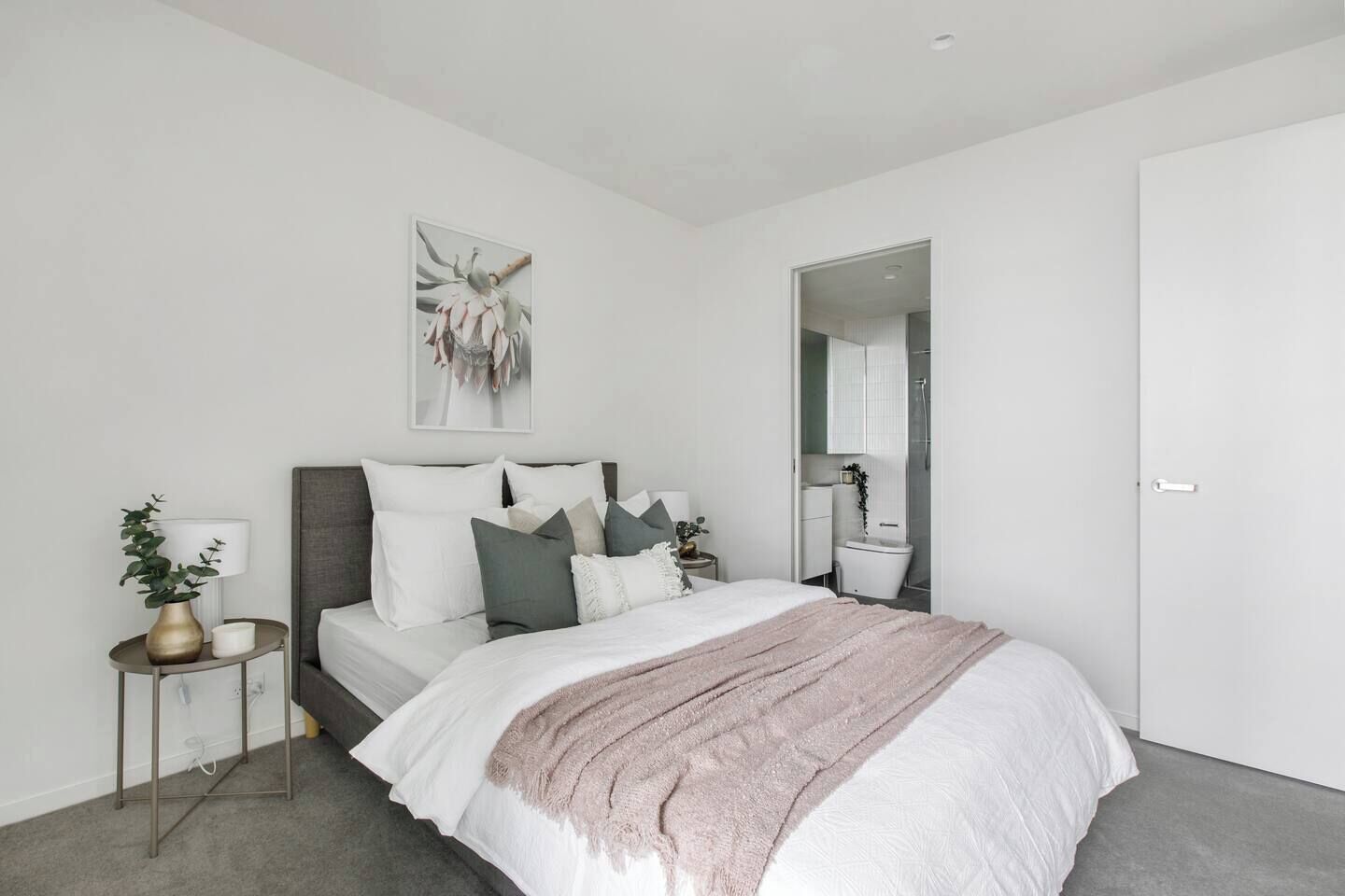 Une chambre à coucher moderne avec un lit, une table de chevet et un miroir.