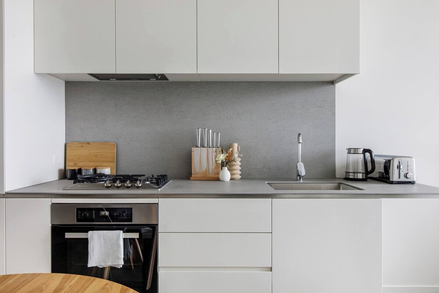 A modern kitchen with a gas stove, a coffee maker, and a toaster.