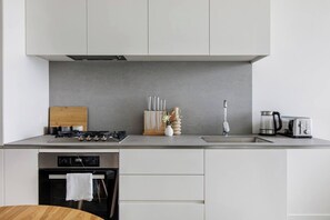 Una cocina moderna con estufa a gas, cafetera y tostadora.