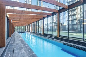 A long indoor swimming pool with a wooden ceiling and large windows. - Sentinel Vista Urban Stay with Pool and Tennis Court (Southbank)