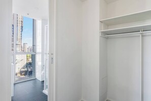En moderne lejlighed med et stort vindue, et walk-in closet og udsigt over bybilledet.