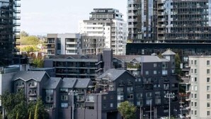 A high-rise building with a modern design, surrounded by other residential buildings. - Urban Calm Comfortable Base with City Views and Gym (South Yarra)