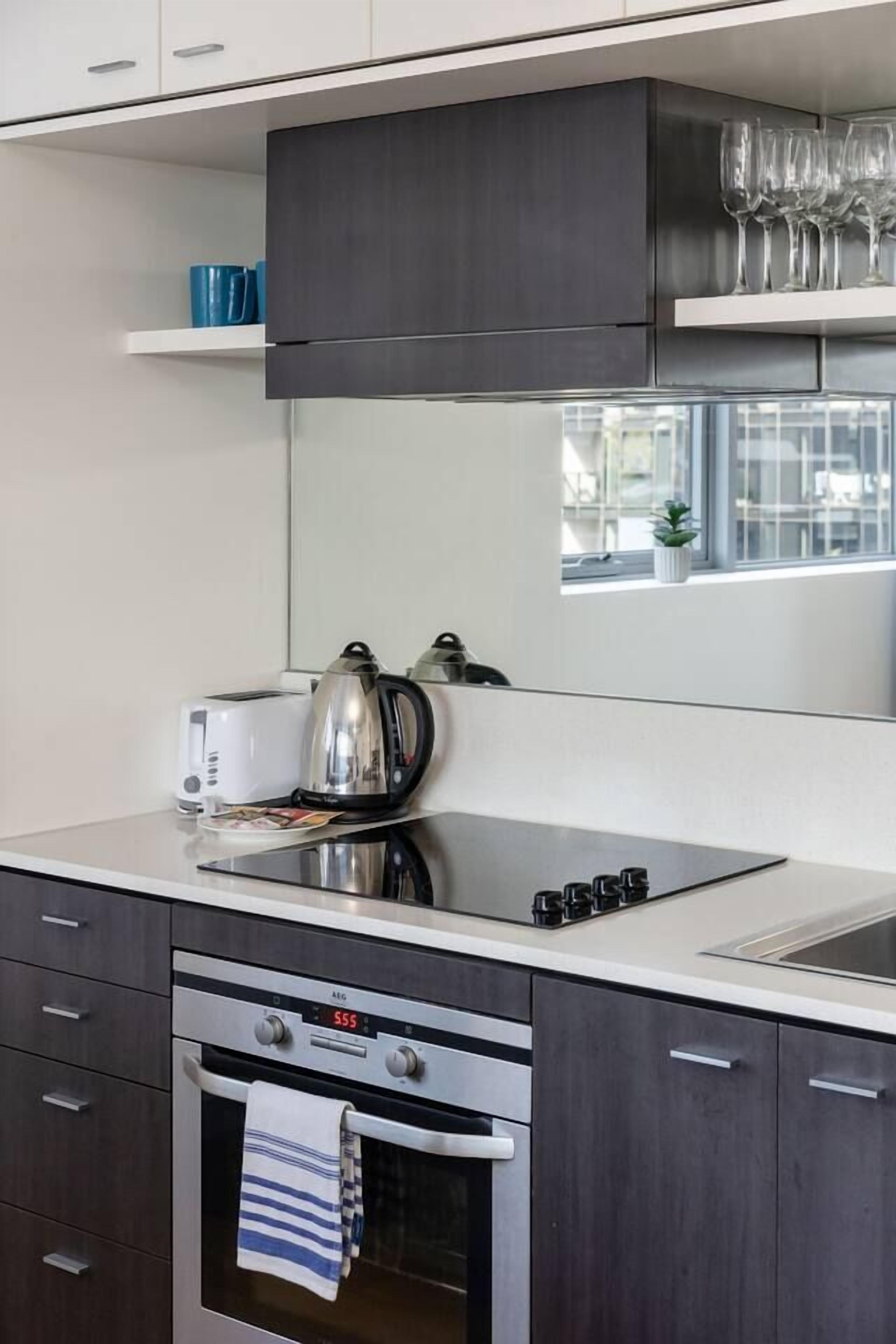 A modern kitchen with a built-in oven, a kettle, and a toaster.