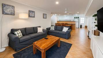 A modern living room with two sofas, a coffee table, and a TV.