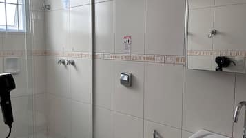 Un baño con inodoro, lavamanos y ducha.