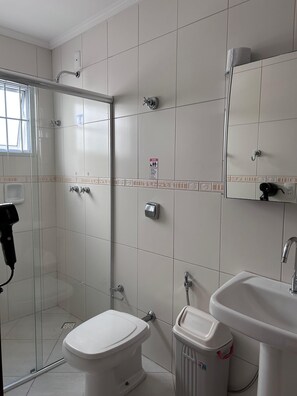 A bathroom with a toilet, sink, and shower.