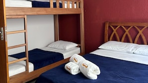 A room with a bunk bed, a single bed, and a ceiling fan.