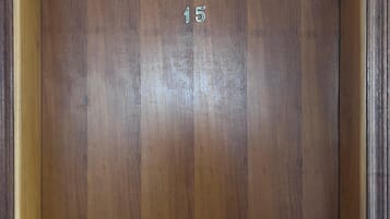 Una puerta de madera con teclado numérico y el número '15' visible.
