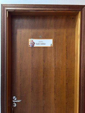 Una puerta de madera con una placa que dice 'Quarto Santo Antônio' y el número 11.