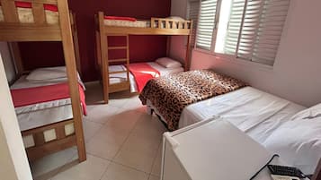 Un dormitorio con literas, una ventana con persianas y un escritorio con teclado.