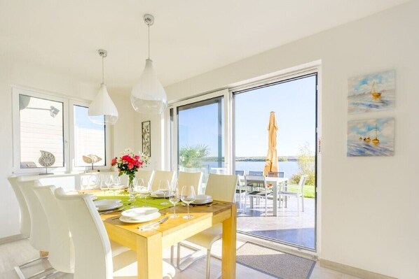 A dining area with a table set for four, large windows, and a view of the outdoors.