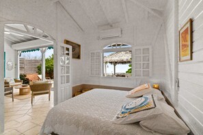 A room with a bed, a window with a view, and a door leading to an outdoor area. - Villa Zouina - Three Bedroom Villa, Sleeps 7 (Le Carbet)