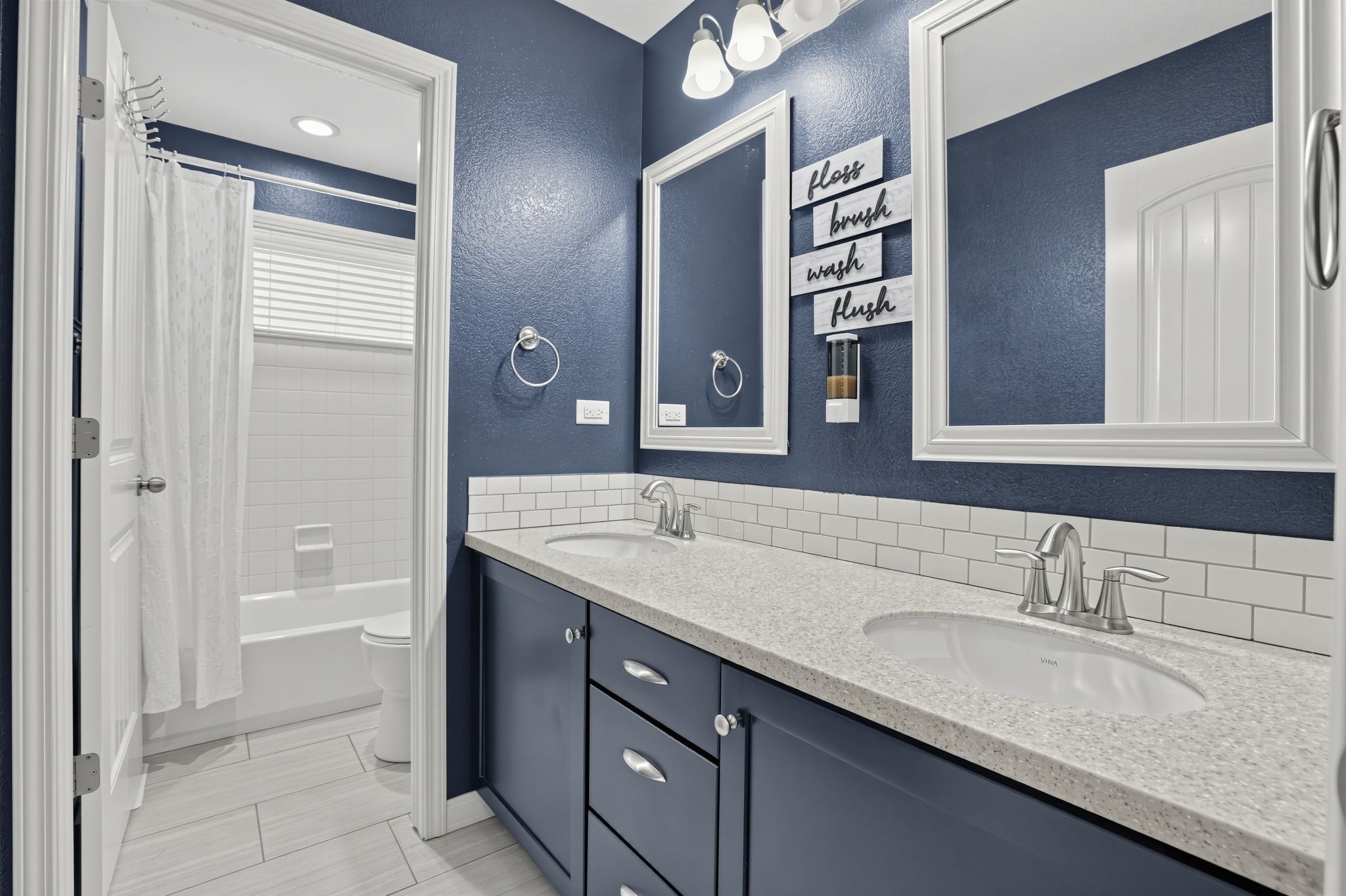 A bathroom with two sinks, a bathtub, and a toilet.