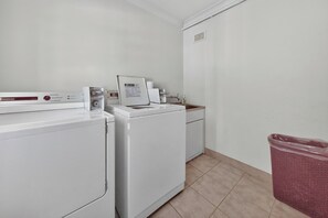 A laundry room with two white washing machines, a small sink, and a trash bin. - Roslyn Studio Between Harbour Calm and City Energy (Potts Point)