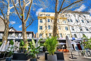 A street with buildings, outdoor seating, and potted plants. - Roslyn Studio Between Harbour Calm and City Energy (Potts Point)