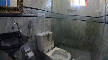 Casa de banho com lavatório, sanita e chuveiro.