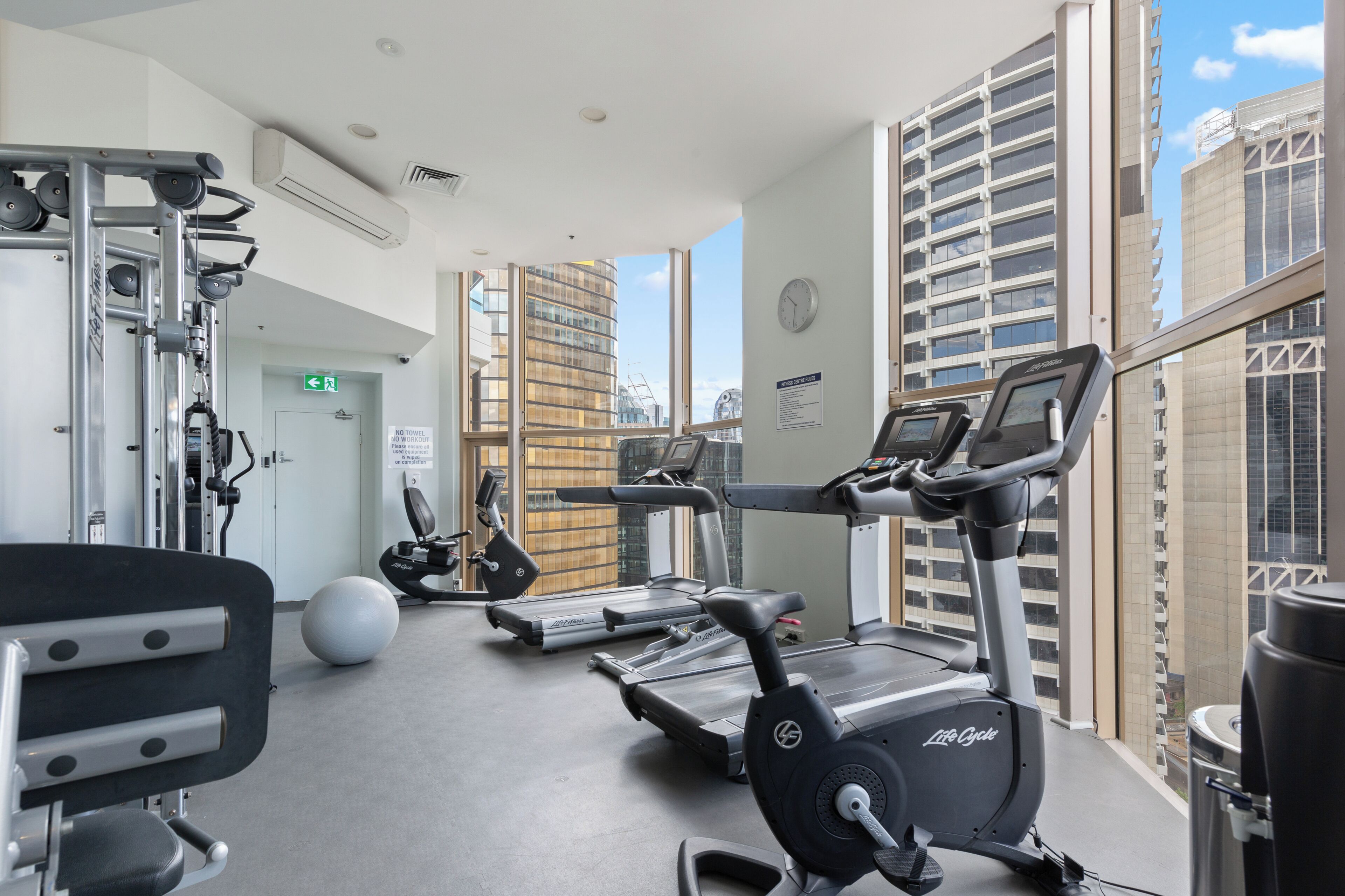 Ein Fitnessstudio mit Laufbändern, Crosstrainern und Gewichten.