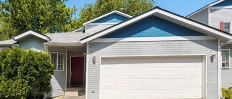 A residential house with a garage, a front door, and a small porch.