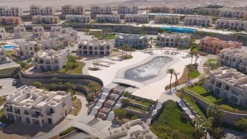 Un quartier résidentiel doté d’une architecture moderne, d’un bassin d’eau central aux formes arrondies et d’une piscine.