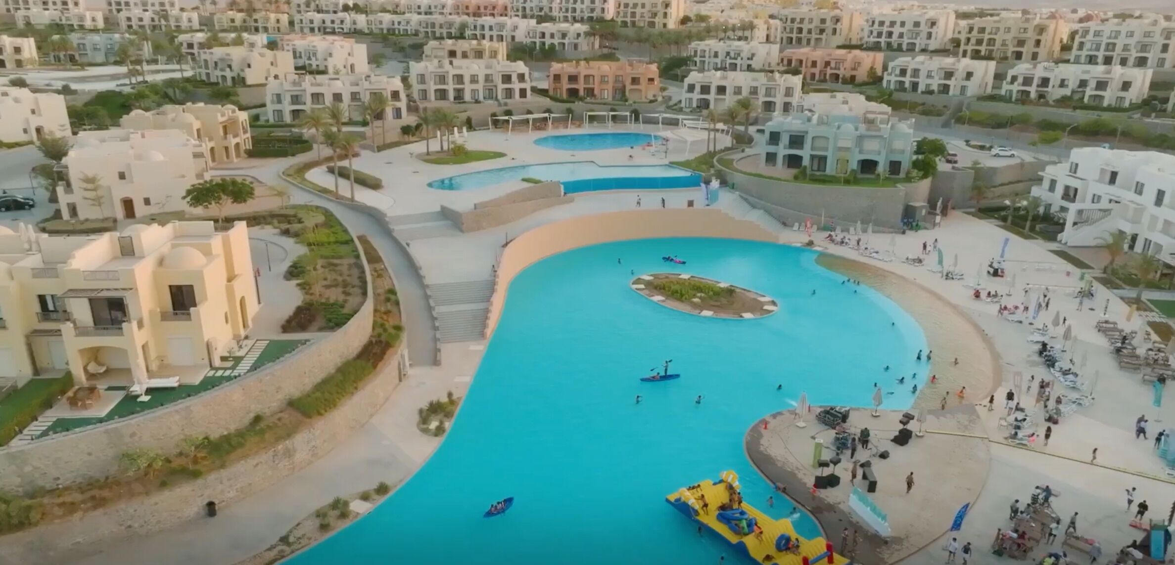 A residential area with a large swimming pool surrounded by modern buildings.