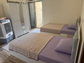Een slaapkamer met twee bedden, een kledingkast en een verwarming.