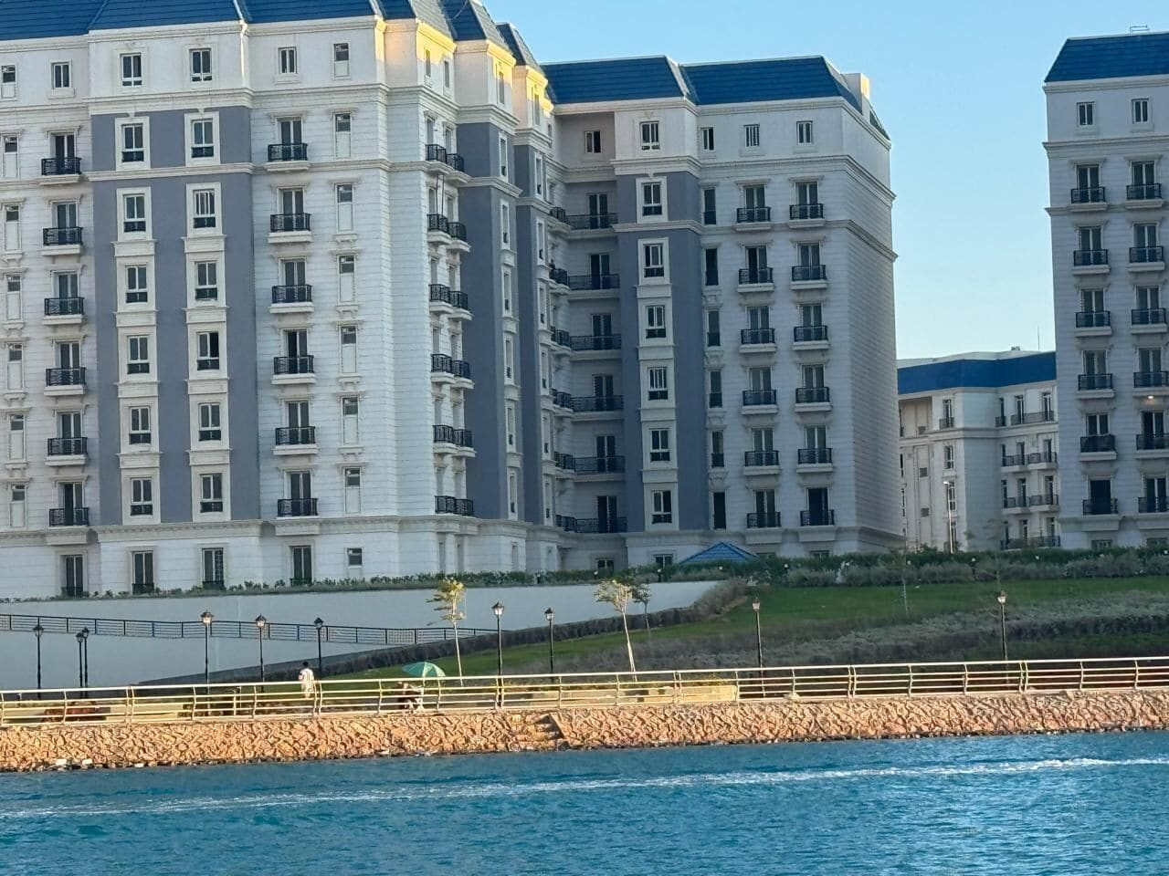 Hotel de varios pisos con balcones, cerca de la costa.