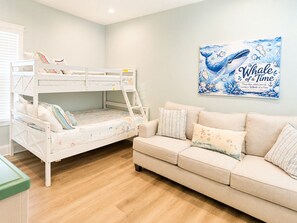 A child's bunk bed with a colorful mattress, a beige sofa with patterned cushions, and a wall with a whale-themed poster. - "How You Dune"
  Serene 3-bedroom house with GULF views in Fort Morgan! (Gulf Shores)