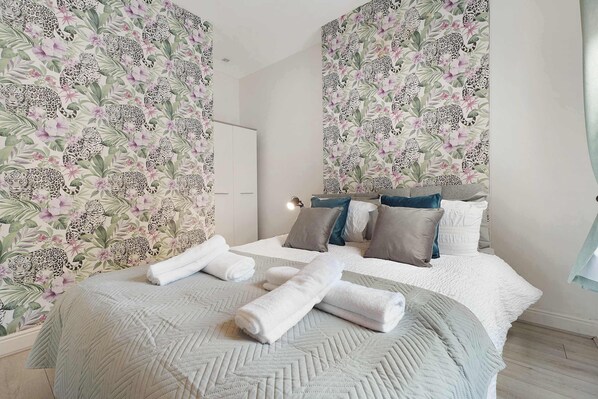 A bedroom with a bed, pillows, and towels. - Cozy 2BR Home Sleeps 5 with WiFi by Stay With Us (Platt Bridge)