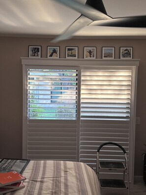 A bedroom with a bed, a chair, a window with blinds, and a ceiling fan. - Fantastic 3-bedroom condo  in lovely Palm Desert. Location, Location, Location! (Palm Desert)