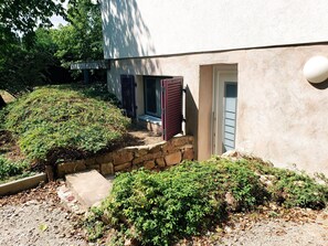 A building with a stone pathway leading to a door, surrounded by greenery. - BNBs-Chic-Colmar-Ribeauvillé (Ribeauvillé)