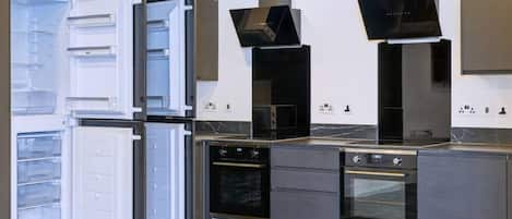 Una cocina moderna con horno empotrado, microondas y refrigerador de doble puerta.
