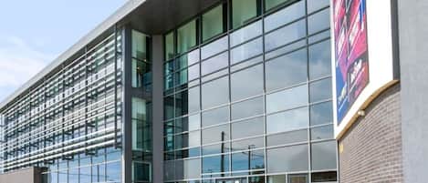 En moderne bygning med store glasruder og en murstensfacade.
