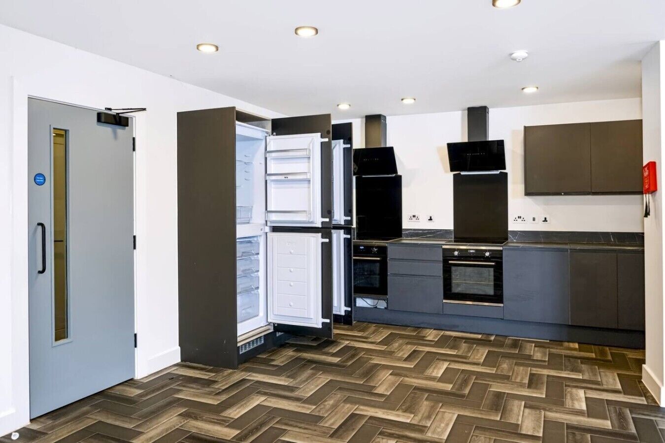A modern kitchen with a built-in refrigerator, oven, and microwave.