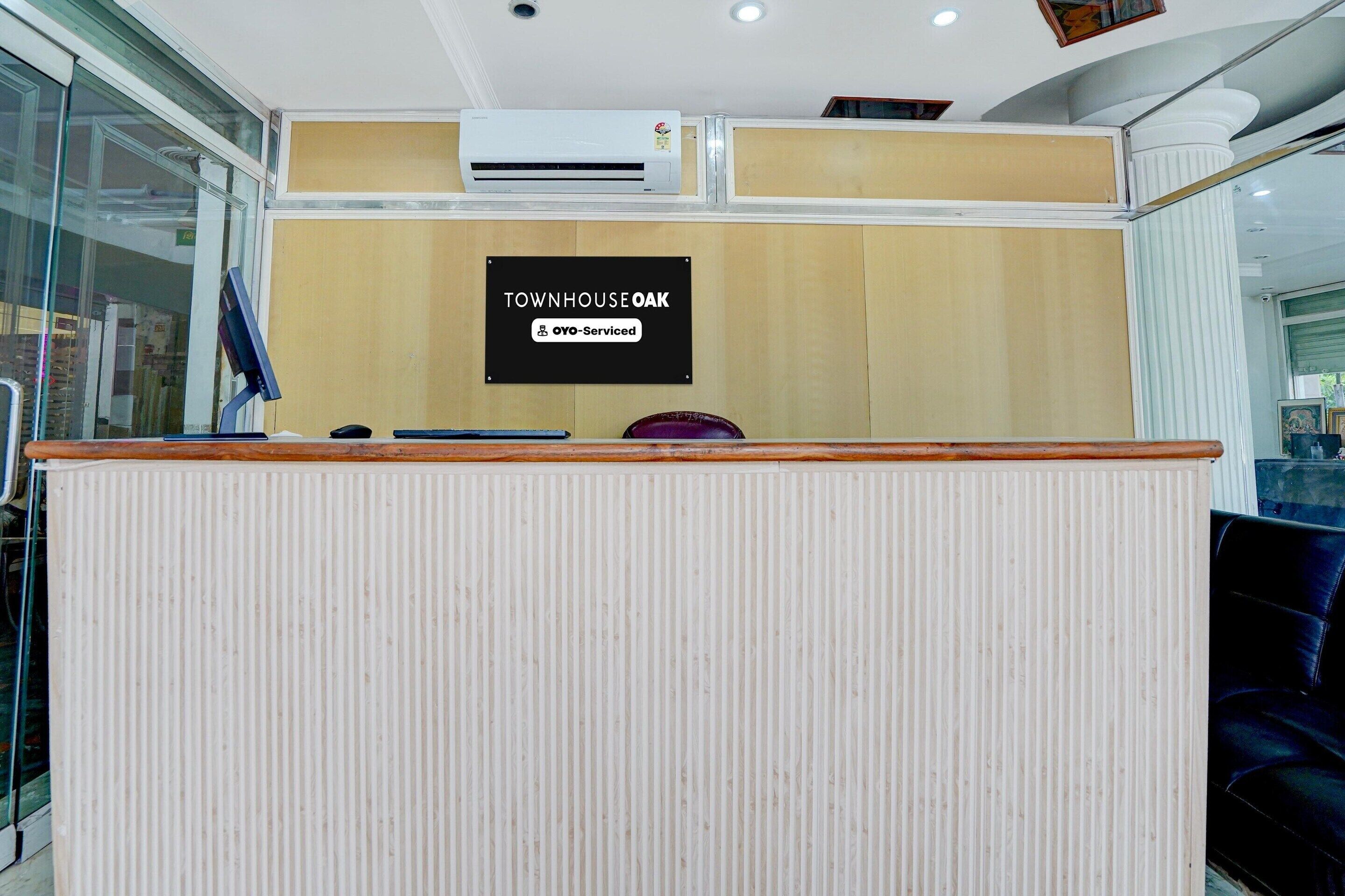 A reception desk with a sign indicating 'TOWNHOUSE OAK' and 'OYO-Serviced.'