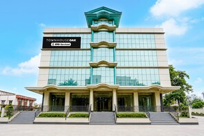A multi-story building with a sign reading 'TOWNHOUSE OAK' and 'YO-Service'.
