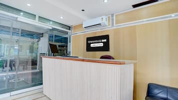 A reception desk with a sign that reads 'TOWNHOUSE OAK' and 'oyo-Serviced'.