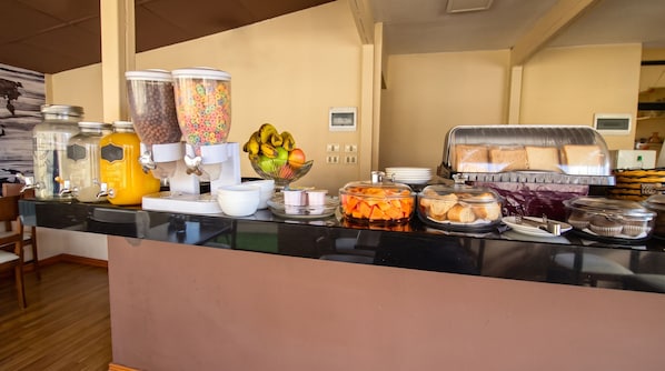 A breakfast buffet with various food items and beverages. - Hotel Monte Carlo (La Paz)