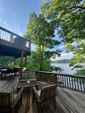 A wooden deck with outdoor furniture overlooking a lake. - 5-bedroom lakefront home with private dock, swim platform, fishing & more! (Camdenton)