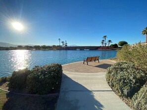 A bench by a body of water with a clear sky and distant mountains. - private pool + spa + game room + near Coachella | Family & Group Friendly (Indio)