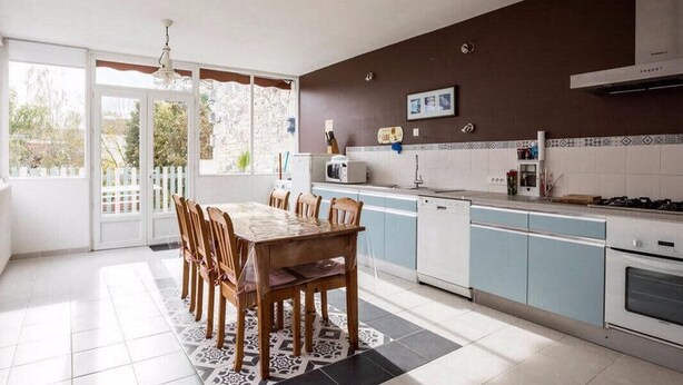 A kitchen with a dining table, chairs, a microwave, and a stove. - "L'Hermione," Rochefort, close to the town center (Rochefort)