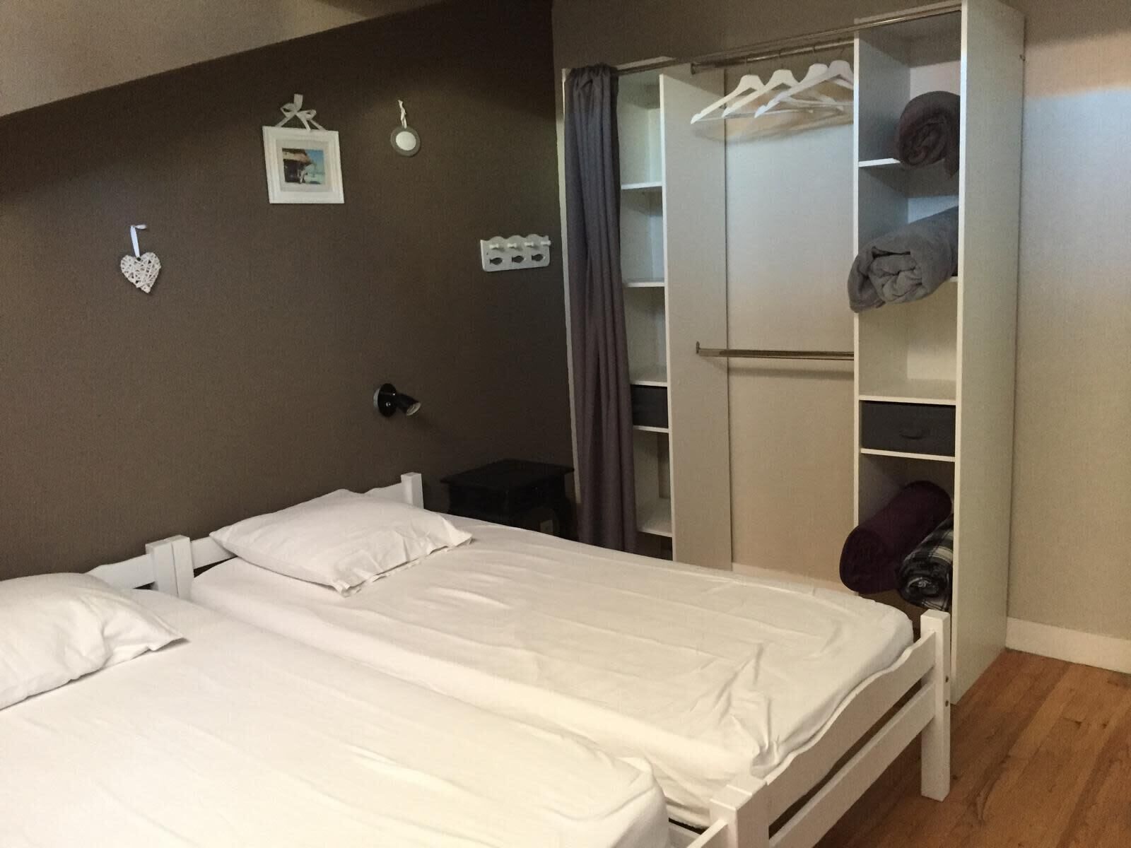 Une chambre à coucher avec un lit, une armoire et une table de chevet.