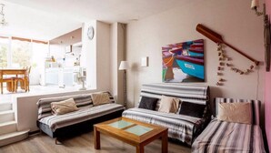 A living room with a sofa, a coffee table, and a painting on the wall. - "L'Hermione," Rochefort, close to the town center (Rochefort)